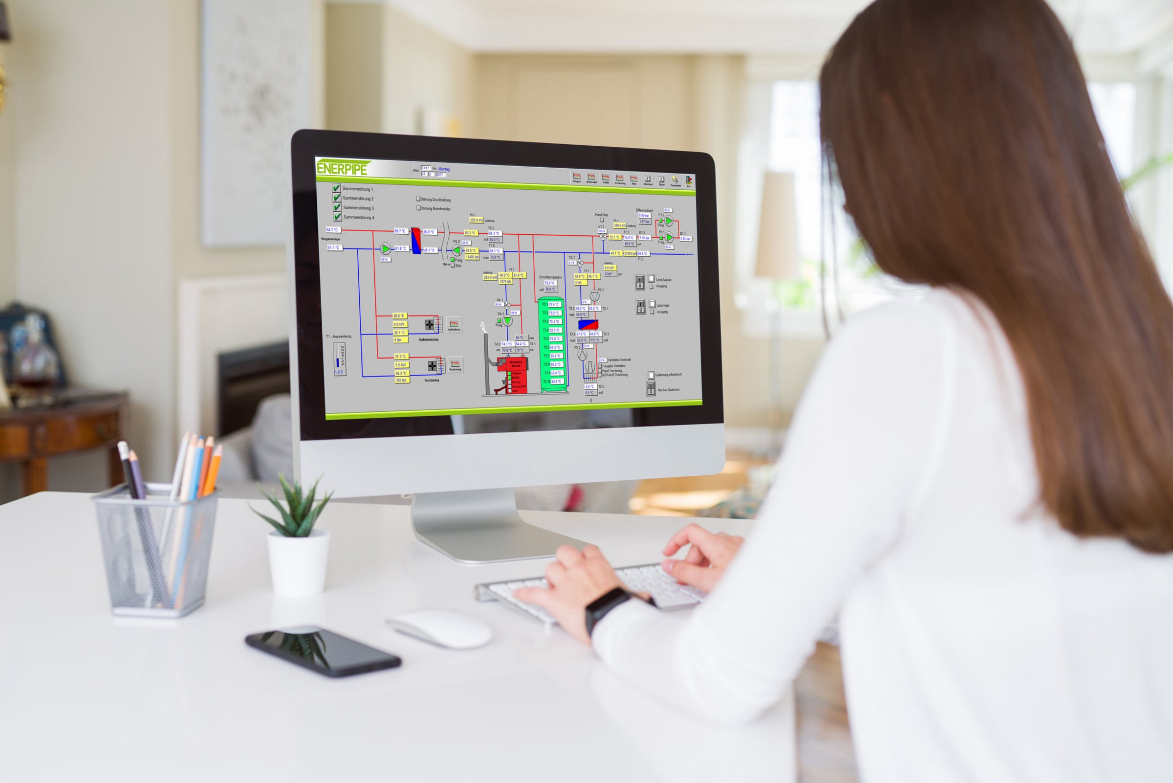 Frau sitzt am PC, der Visualisierung eines Wärmenetzes